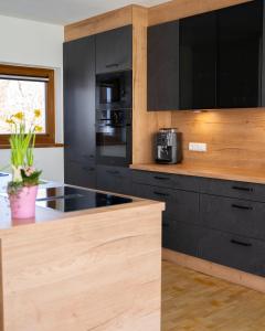 eine Küche mit schwarzen Schränken und schwarzen Geräten in der Unterkunft Eva Apartments - Patscherkofel in Innsbruck