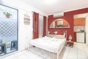een slaapkamer met een wit bed en een keuken bij Oasis Studios in the City Centre in Heraklion