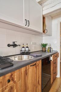 una cocina con fregadero y armarios de madera en Warm & Friendly Apartment II., en Budapest