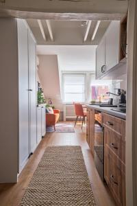 cocina con armarios blancos y alfombra de cocina en Warm & Friendly Apartment II., en Budapest