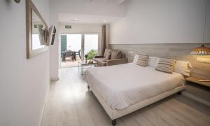 a bedroom with a large bed and a living room at Xubec - Albergue Juvenil in Ciutadella