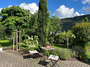 a garden with a table and chairs in the middle of a garden at York Cottage Garden in Traben-Trarbach