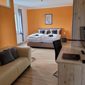 ein Hotelzimmer mit einem Bett und einem Sofa in der Unterkunft Gästehaus Dahmen in Stolberg