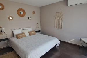 una camera da letto bianca con un letto e uno specchio di Maison de vacances avec piscine proche mer et montagne a Ghisonaccia Altre 38 foto