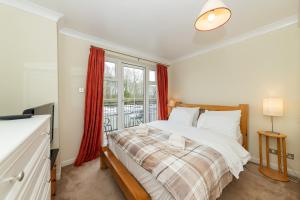 um quarto com uma cama e uma janela em Large Tranquil Riverside Flat with Thames Views - Pass the Keys em Reading