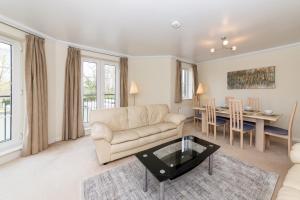 uma sala de estar com um sofá e uma mesa em Large Tranquil Riverside Flat with Thames Views - Pass the Keys em Reading