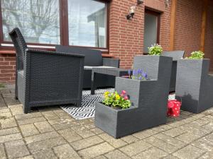 a group of chairs and flowers on a patio at Ferienwohnung im Vorharz in Liebenburg