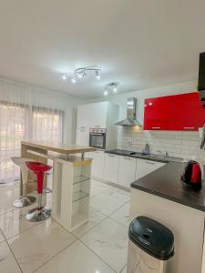 una cocina con armarios rojos y un taburete rojo. en 3 holiday apartments with shared pool, peaceful location, en Pula