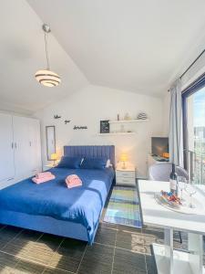Un dormitorio con una cama azul y una mesa en 3 holiday apartments with shared pool, peaceful location, en Pula