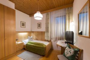 a hotel room with a bed and a tv at Alpin Natur Hotel Brückele in Braies