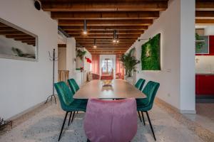 une salle à manger avec une table et des chaises vertes dans l'établissement Villa Venice Carnival - Wellness, à Mira