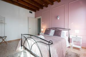 - une chambre avec un grand lit aux murs roses dans l'établissement Villa Venice Carnival - Wellness, à Mira