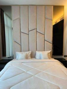 1 cama blanca grande en una habitación con pared en Harbor Row, en Manama