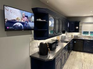 a kitchen with a flat screen tv on the wall at Mac's Cottage in Clogher