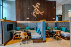 a restaurant with blue chairs and tables and a tv at Courtyard by Marriott Santiago Airport in Santiago