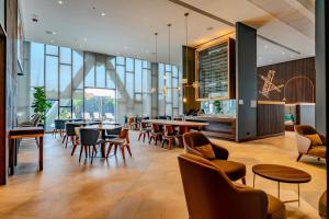 a restaurant with tables and chairs and windows at Courtyard by Marriott Santiago Airport in Santiago
