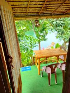 a table and chairs on a porch with a view at คลองแสงฟาร์มสเตย์ in Ban Ta Khun