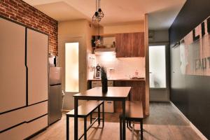 een kleine keuken met een tafel en een koelkast bij Big Apple - Studio paisible - parking gratuit - 2 personnes in Auxerre