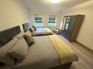 a large bedroom with two beds and a chair at Mac's Cottage in Clogher
