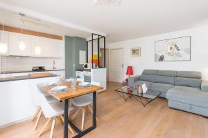 uma cozinha e sala de estar com uma mesa e um sofá em Spacieux appartement - Parking privé & Piscine em Beausoleil