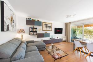 uma sala de estar com um sofá e uma mesa em Spacieux appartement - Parking privé & Piscine em Beausoleil