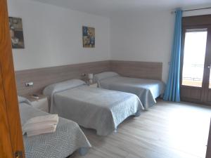 a hospital room with two beds and a window at Hostal Casa Fermina- A 2 horas de las pistas de esquí in Trevélez