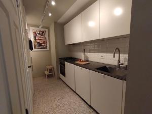 a kitchen with white cabinets and a sink at Sjarmerende, sentrumsnær leilighet in Stavanger