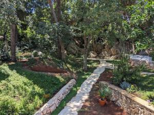 un giardino con un sentiero in pietra e alcune piante di Lucia's Residence a Mlini