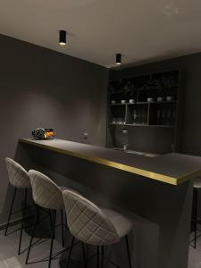 a kitchen with a counter with two stools at a bar at Hotel Atria in Braşov