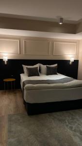 a bedroom with a large bed and a table at Hotel Atria in Braşov