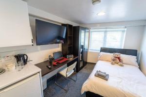 a bedroom with a bed with a teddy bear on it at Spacious Comfortable studio near the university in Birmingham