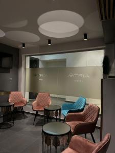 a waiting area with chairs and tables in a building at Hotel Atria in Braşov