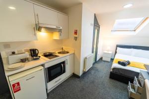 een kleine kamer met een keuken en een bed bij Spacious Comfortable studio near the university in Birmingham