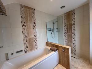 a large bathroom with a tub and a shower at The Bay Tree in Alton