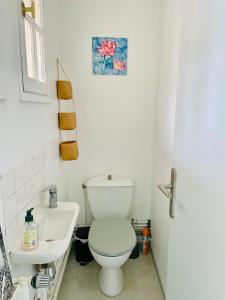 ein weißes Bad mit einem WC und einem Waschbecken in der Unterkunft Rooms with garden in Luckyhouse Maison Chatou Paris La Défense in Chatou