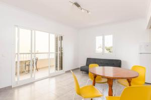 een woonkamer met een tafel en stoelen en een bank bij Acapulco Apartments in Can Picafort