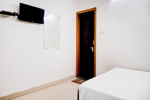 una camera con porta, letto e televisore di Flagship Hotel Lotus Inn a Varanasi