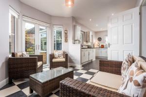 a living room with wicker furniture and a kitchen at 45 Doonvale Drive in Ayr