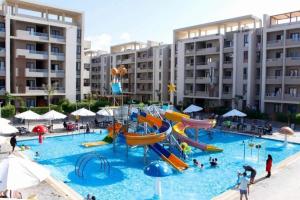 a large swimming pool with a water park with slides at شاليه عائلي في قرية جراند هيلز طابق أرضي بحديقة خاصة غرفتين نوم وريسبشن واسع in Dawwār ‘Abd Allāh