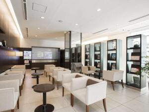a waiting room with white chairs and tables at Cross Wave Umeda in Osaka