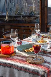 una mesa con vasos y platos de comida. en Korunka, en Tatariv