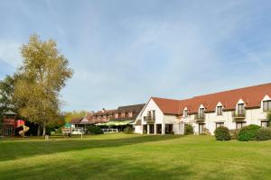 a large building with a grass field in front of it at Logis Le Relais De Pouilly in Pouilly-sur-Loire