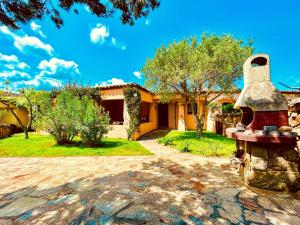 ein Haus mit einer Glocke davor in der Unterkunft Sweet Home Villetta a Schiera With Pool in Baja Sardinia