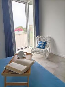 une chambre avec une table, un livre et une chaise dans l'établissement Casalulù Holiday Home - Lovely Apartment Sorrento Coast, à Vico Equense