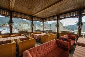 a restaurant with tables and chairs and mountains in the background at Koruna in Tatariv