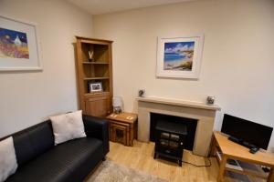 a living room with a couch and a fireplace at Argyll House The Byre in Salen
