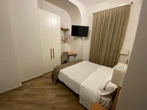 um quarto de hotel com uma cama e uma televisão em A 4 PASSI em Reggio di Calabria