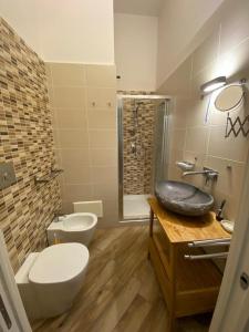 uma casa de banho com um WC, um lavatório e um chuveiro em A 4 PASSI em Reggio di Calabria