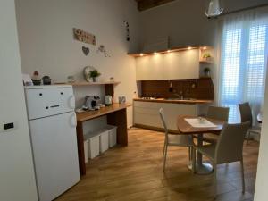 uma cozinha com uma mesa e um frigorífico branco em A 4 PASSI em Reggio di Calabria