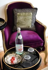 a bottle of water and two glasses on a table in front of a chair at Rye Treat in Rye